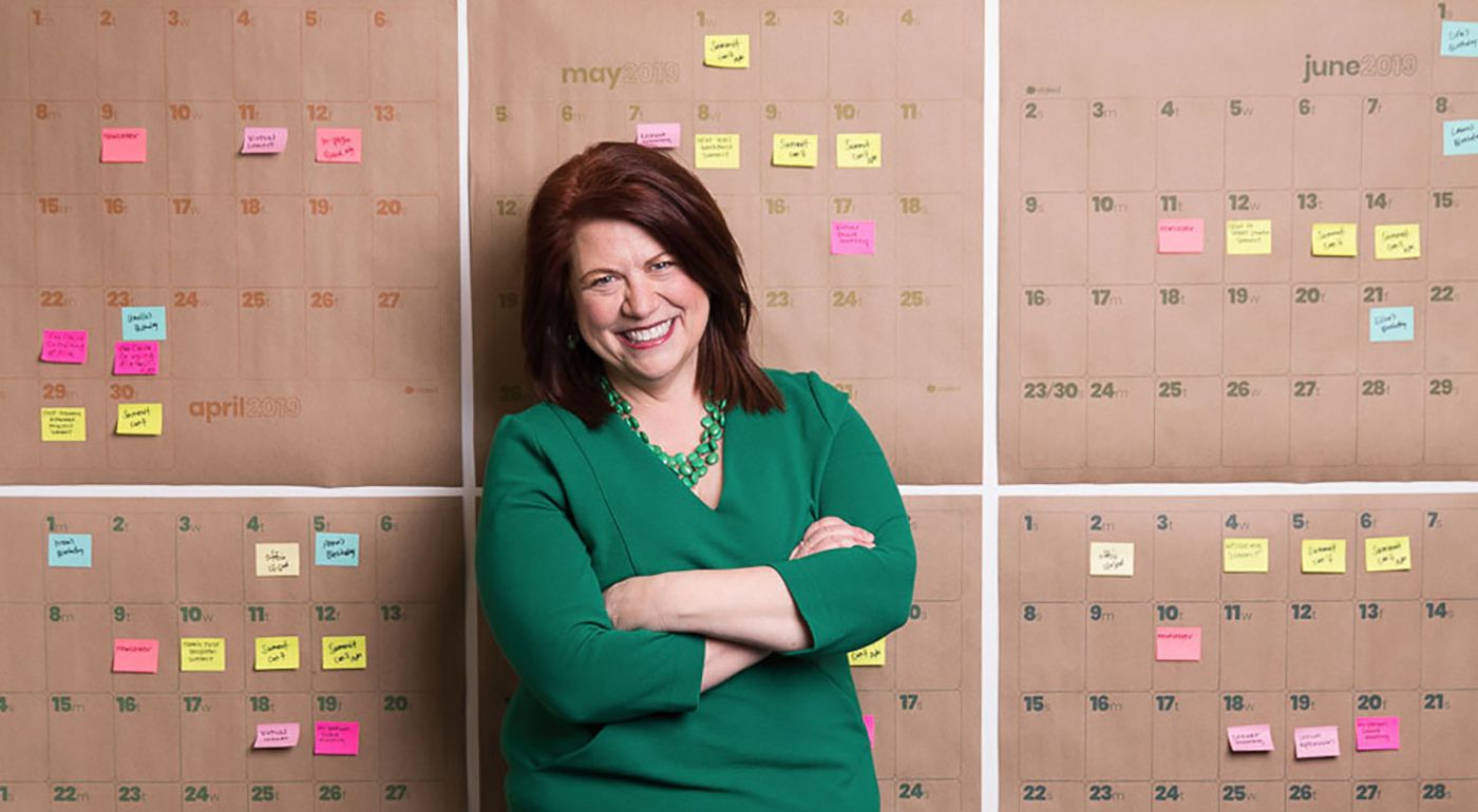 Amelia Franck Meyer standing in front of wall of colorful post-it notes