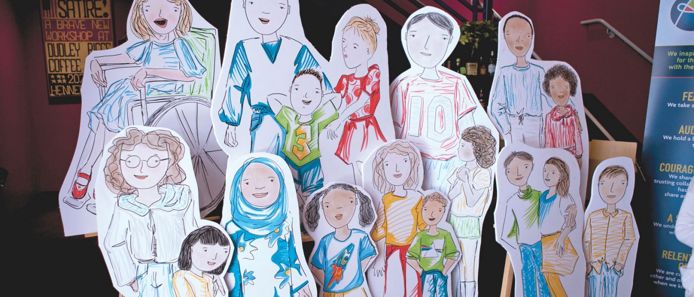 A group of life-sized cardboard cutouts of illustrated diverse children.